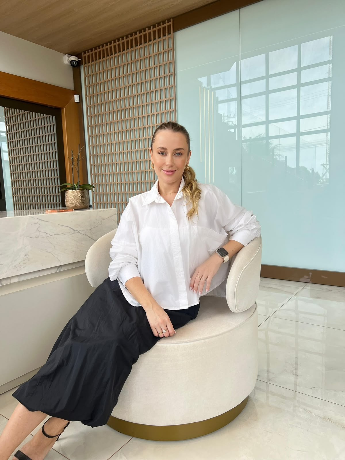 Charline Backes sentada na recepção da clínica